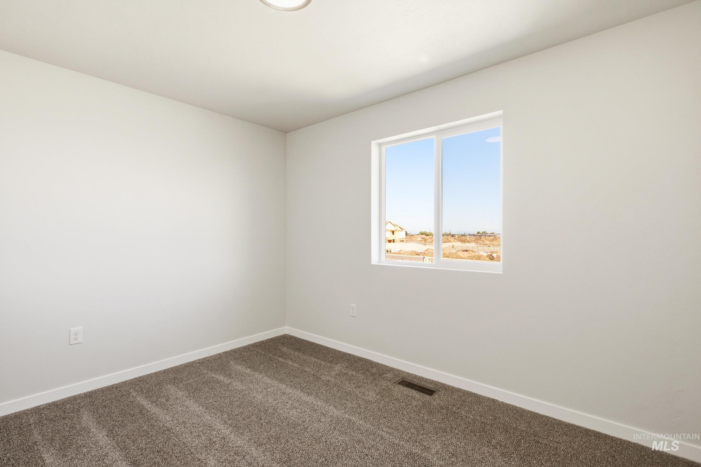 10806 Rutland Street Caldwell, ID 83605 - Photo 14 of 21 Neutral toned room featuring plush gray carpeting, white walls, and a single window with white trim