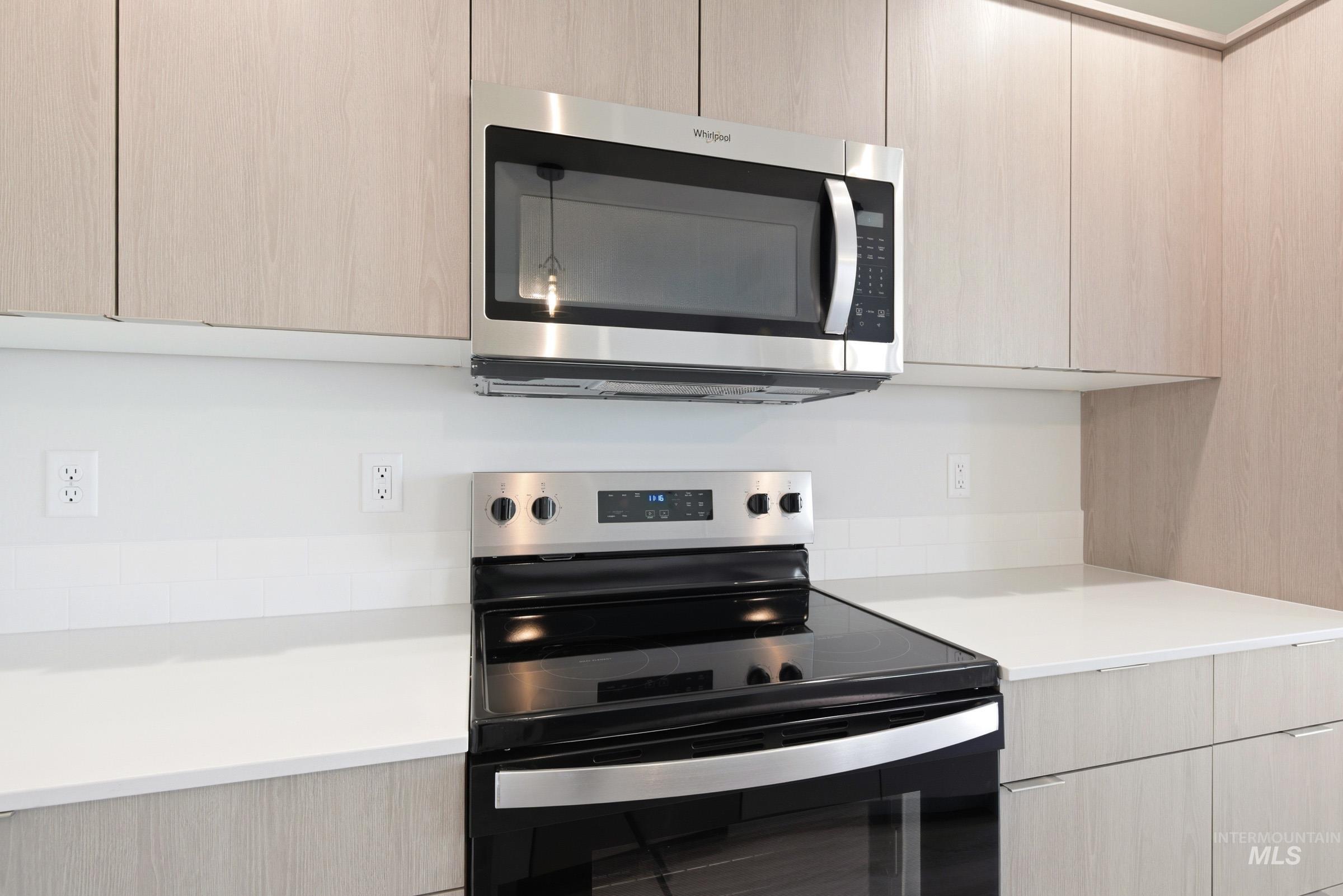 10806 Rutland Street Caldwell, ID 83605 - Photo 5 of 21 Kitchen featuring light wood-finish cabinetry, a stainless steel over-the-range microwave, and a black electric range with a stainless steel control panel