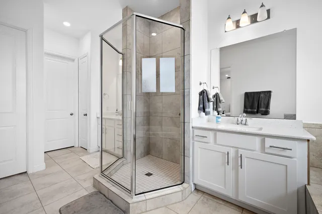 a bathroom with a shower sink and mirror