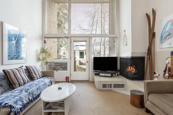 a living room with furniture a flat screen tv and a window