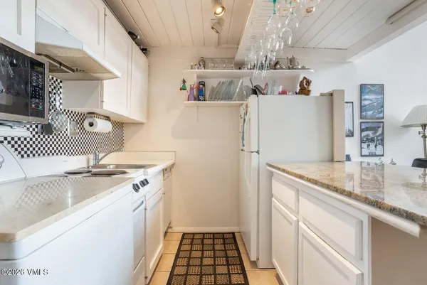 a kitchen with a sink a refrigerator and cabinets