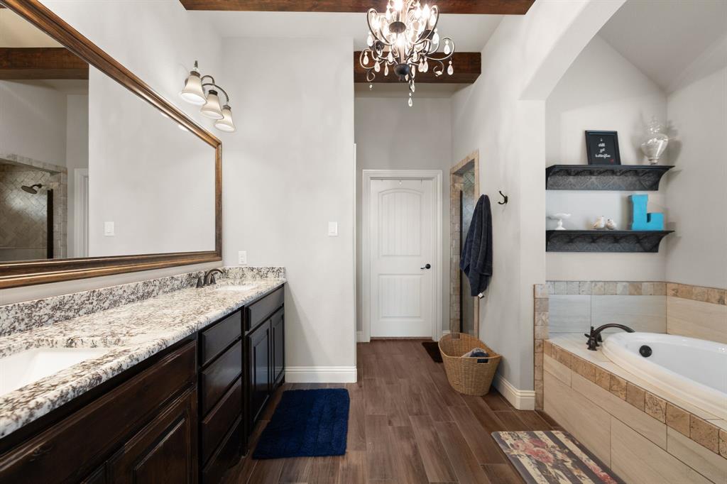 2103 Cash Point Court Granbury, TX 76049 - Photo 18 of 38 a spacious bathroom with a granite countertop double vanity sink a mirror and bathtub