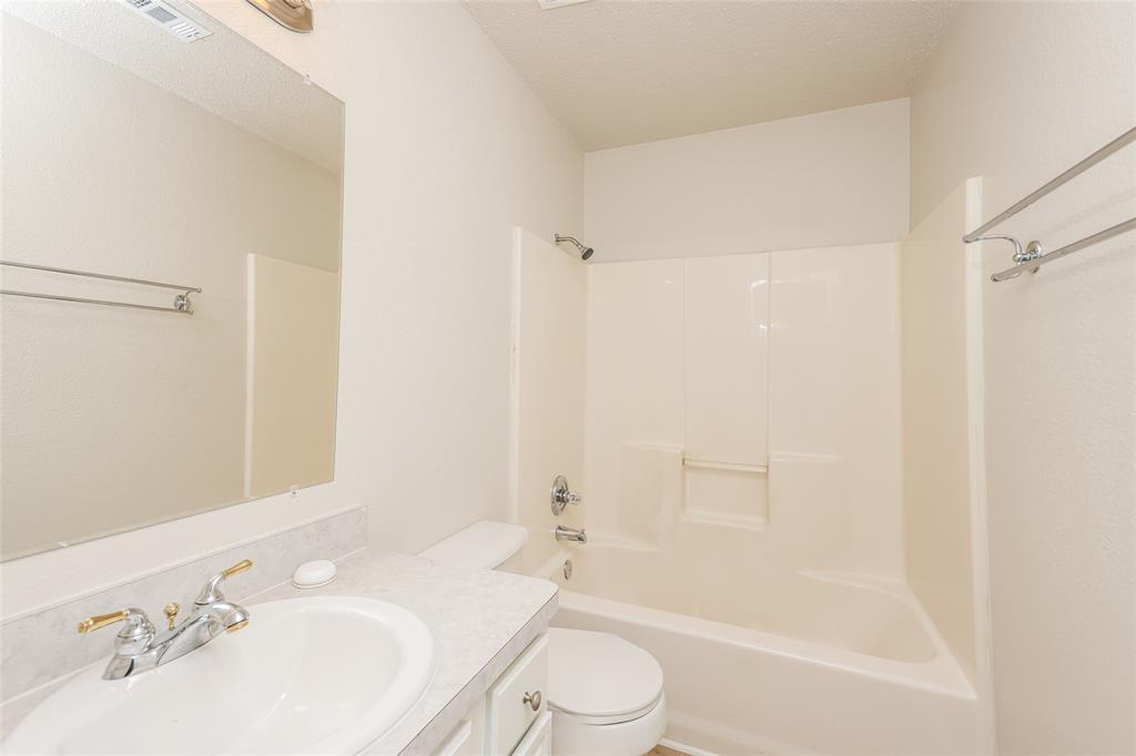 328 Willow Creek Drive Glenn Heights, TX 75154 - Photo 12 of 16 a bathroom with a bathtub shower sink vanity and toilet