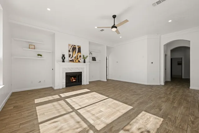 a view of a livingroom with a fireplace chandelier and windows