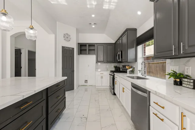 a large kitchen with stainless steel appliances granite countertop a sink and cabinets