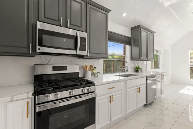 a kitchen with cabinets stainless steel appliances and a sink