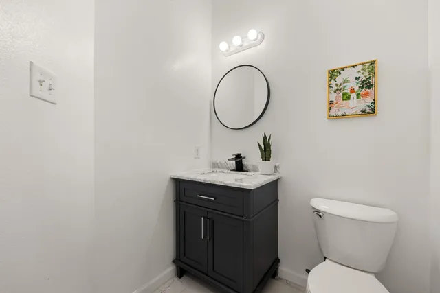 a bathroom with a toilet a sink and mirror