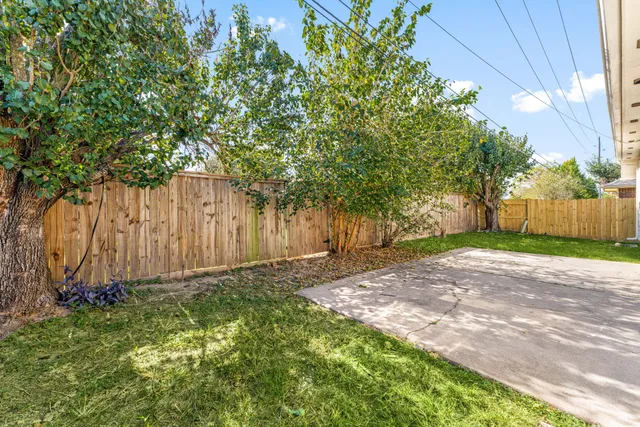 a view of a yard with wooden fence