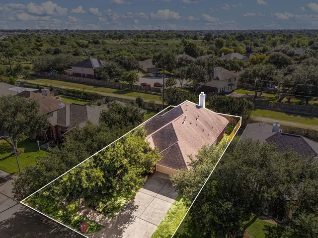 an aerial view of a house with a garden and lake view