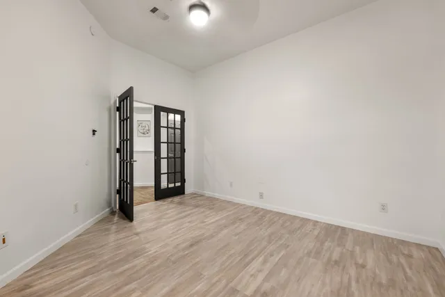 an empty room with wooden floor and mirror