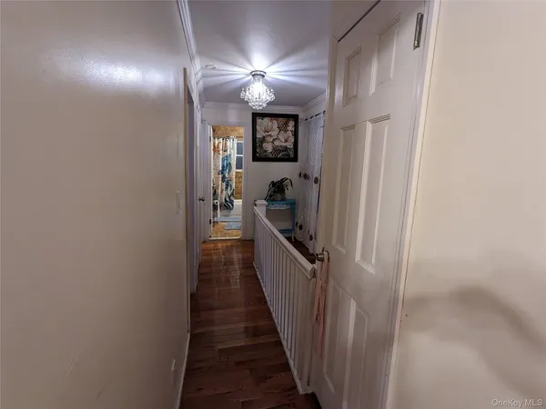 a view of a hallway with a livingroom and a bathroom with sink