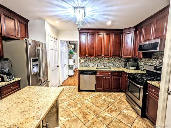a kitchen with stainless steel appliances wooden cabinets a stove top oven a sink and dishwasher