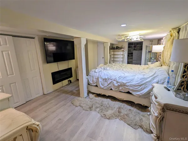 a spacious bedroom with a bed and a flat screen tv