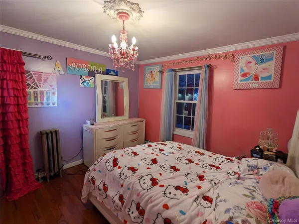 a bedroom with a large bed and a chandelier