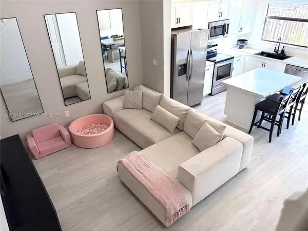 a living room with furniture and wooden floor