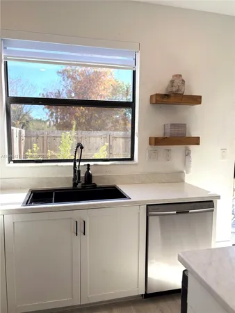 a kitchen with a sink a stove and a window
