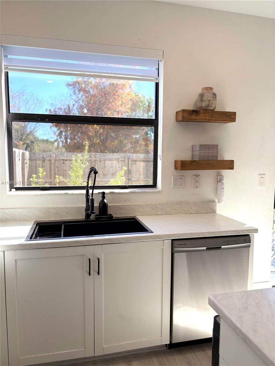 14724 Southwest 181st Terrace Miami, FL 33187 - Photo 13 of 36 a kitchen with a sink a stove and a window