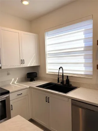 a kitchen with a sink cabinets and window