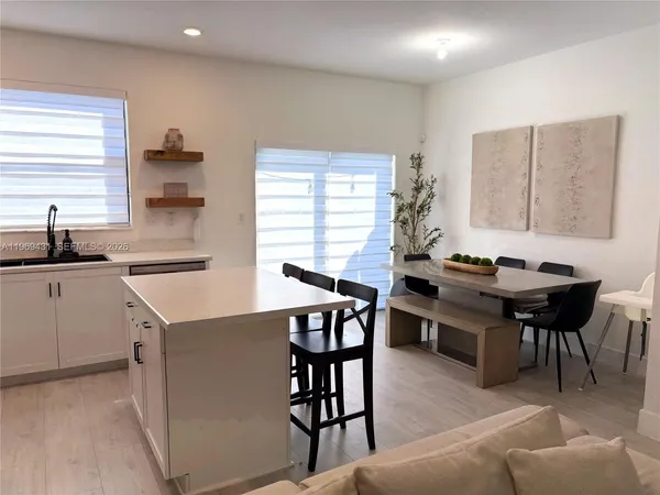 a kitchen with a table chairs sink and cabinets