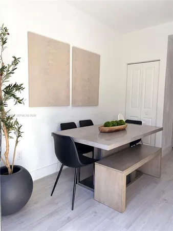 a living room with table and a potted plant