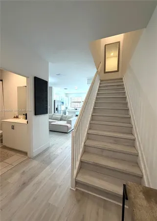 a view of a livingroom with wooden floor and stairs