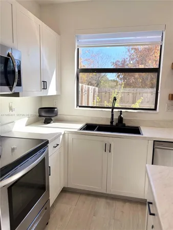 a kitchen with a sink stove and microwave