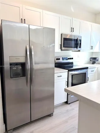 a kitchen with stainless steel appliances a refrigerator stove and microwave