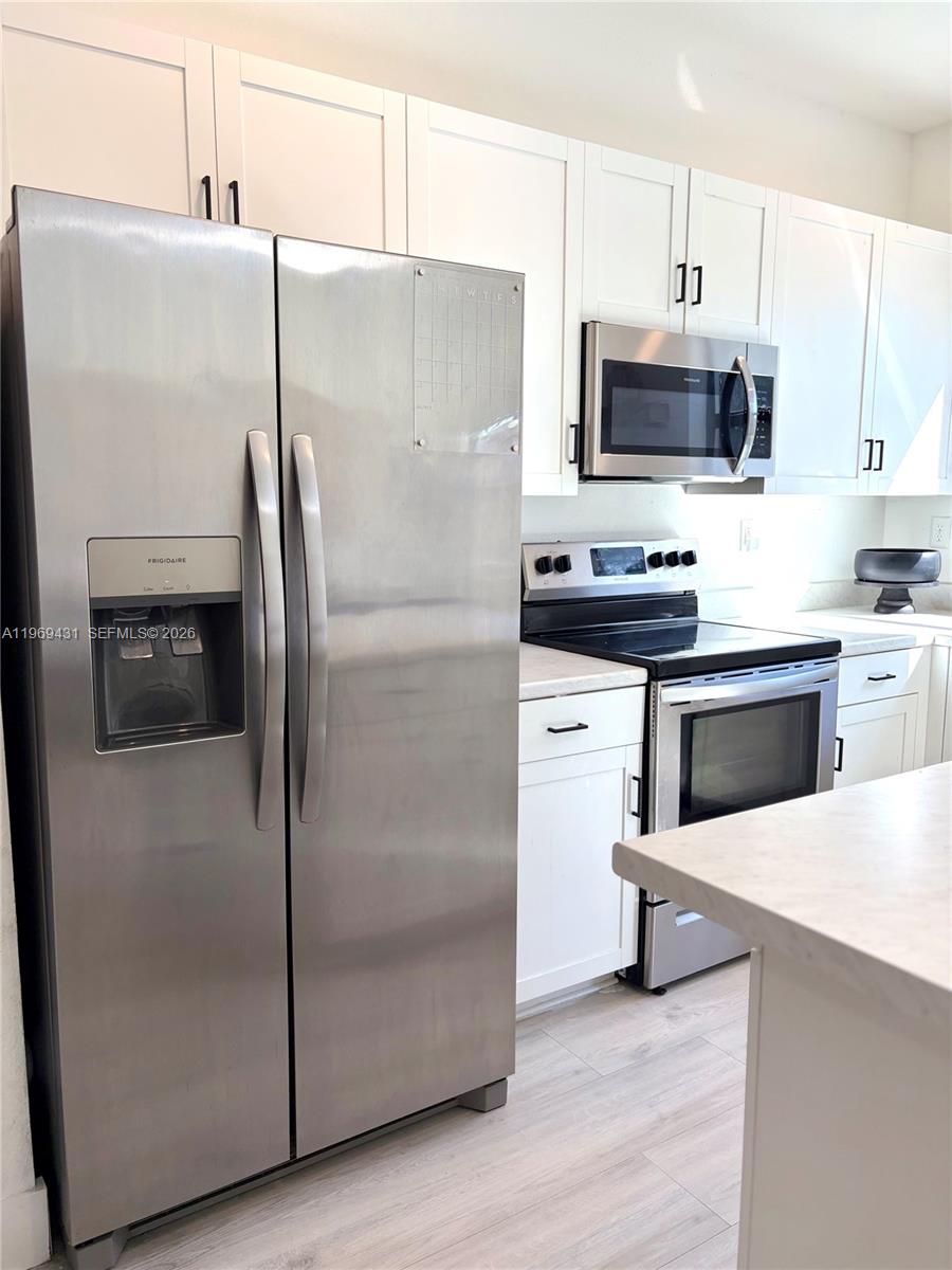 14724 Southwest 181st Terrace Miami, FL 33187 - Photo 5 of 36 a kitchen with stainless steel appliances a refrigerator stove and microwave