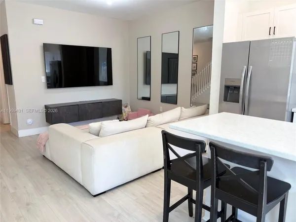 a living room with stainless steel appliances furniture a counter top space and a view of kitchen