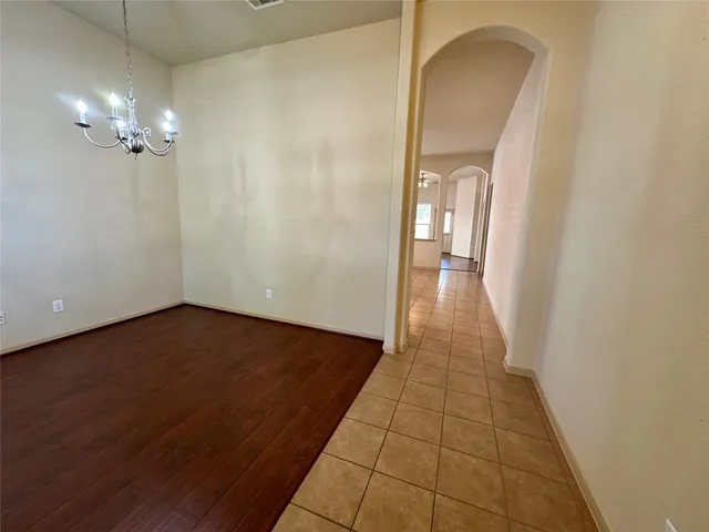 a view of a room with wooden floor and a chandelier