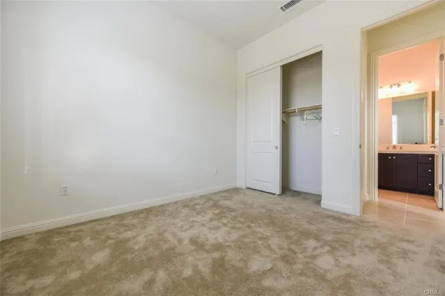 an empty room with closet and mirror