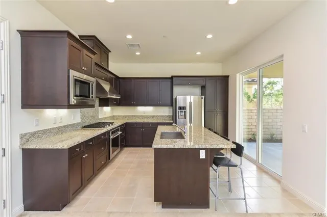 a kitchen with stainless steel appliances granite countertop a sink and a stove