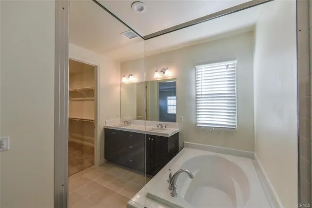 a bathroom with a tub sink and mirror