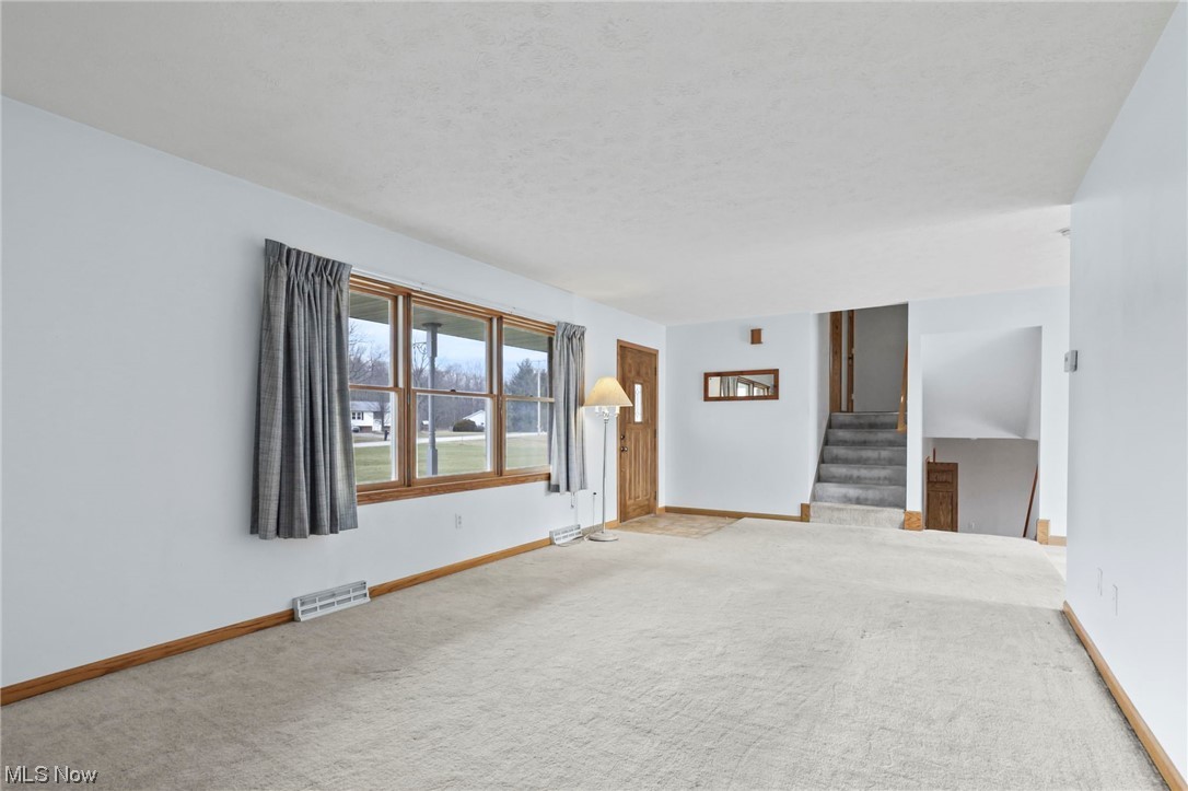 411 Adario West Road Shiloh, OH 44878 - Photo 4 of 35 Unfurnished living room with carpet flooring