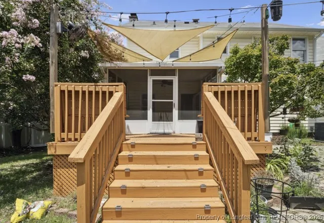 a view of a house with wooden stairs and a table and chairs