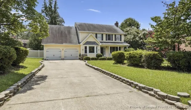 a front view of a house with a garden and yard