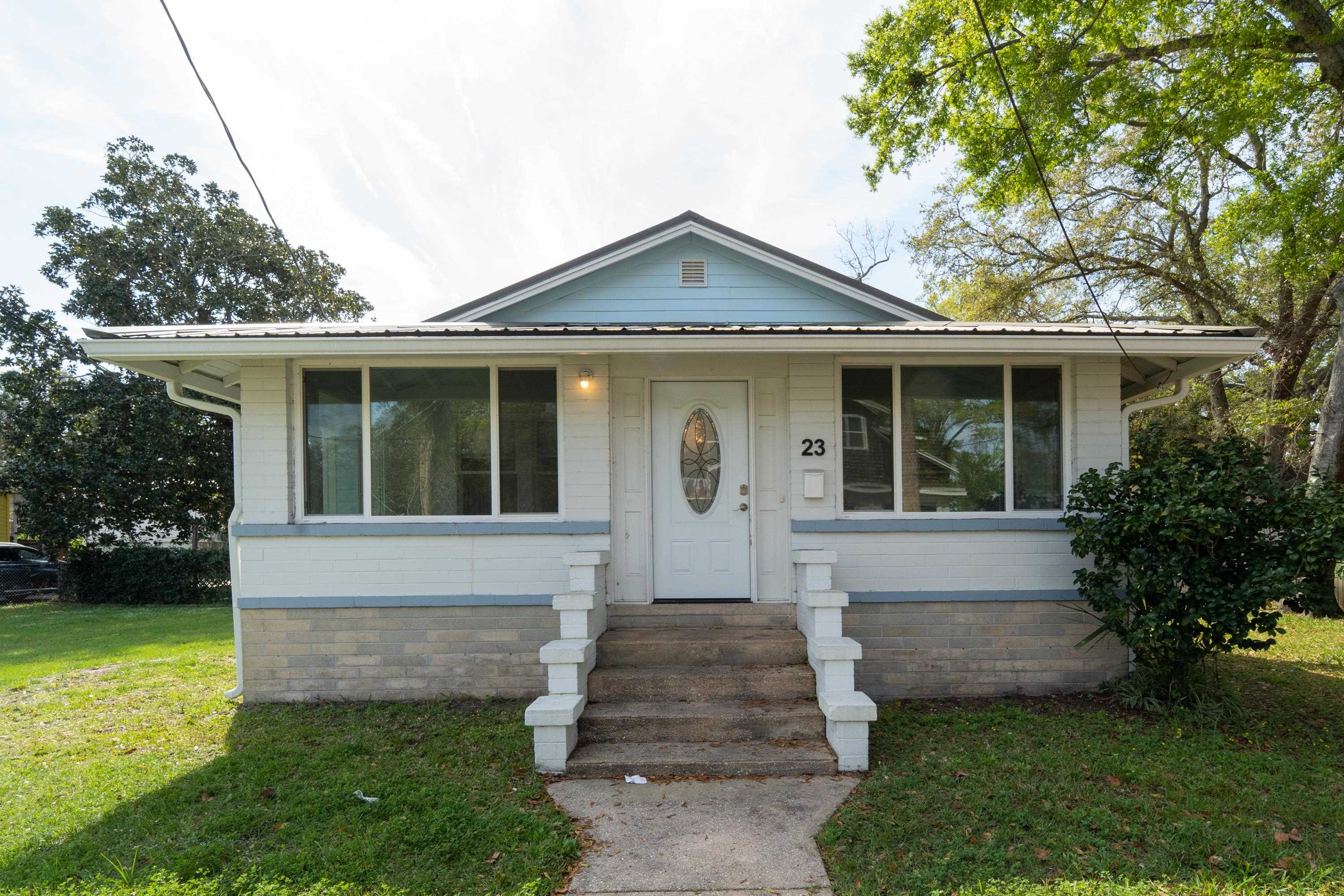 Bungalow-style house featuring a metal roof, entry steps, and a front yard