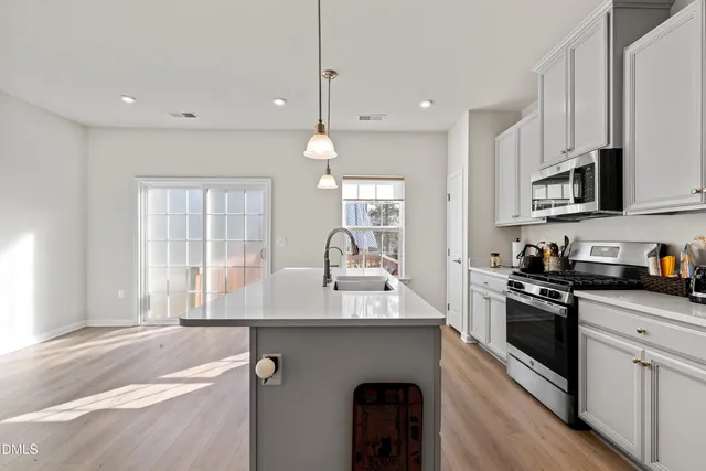 a kitchen with stainless steel appliances granite countertop a refrigerator a stove a sink and a microwave