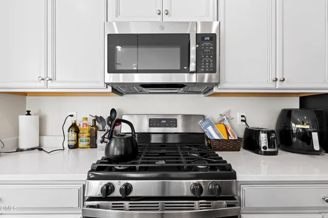 a kitchen with stainless steel appliances granite countertop a sink a stove and a refrigerator