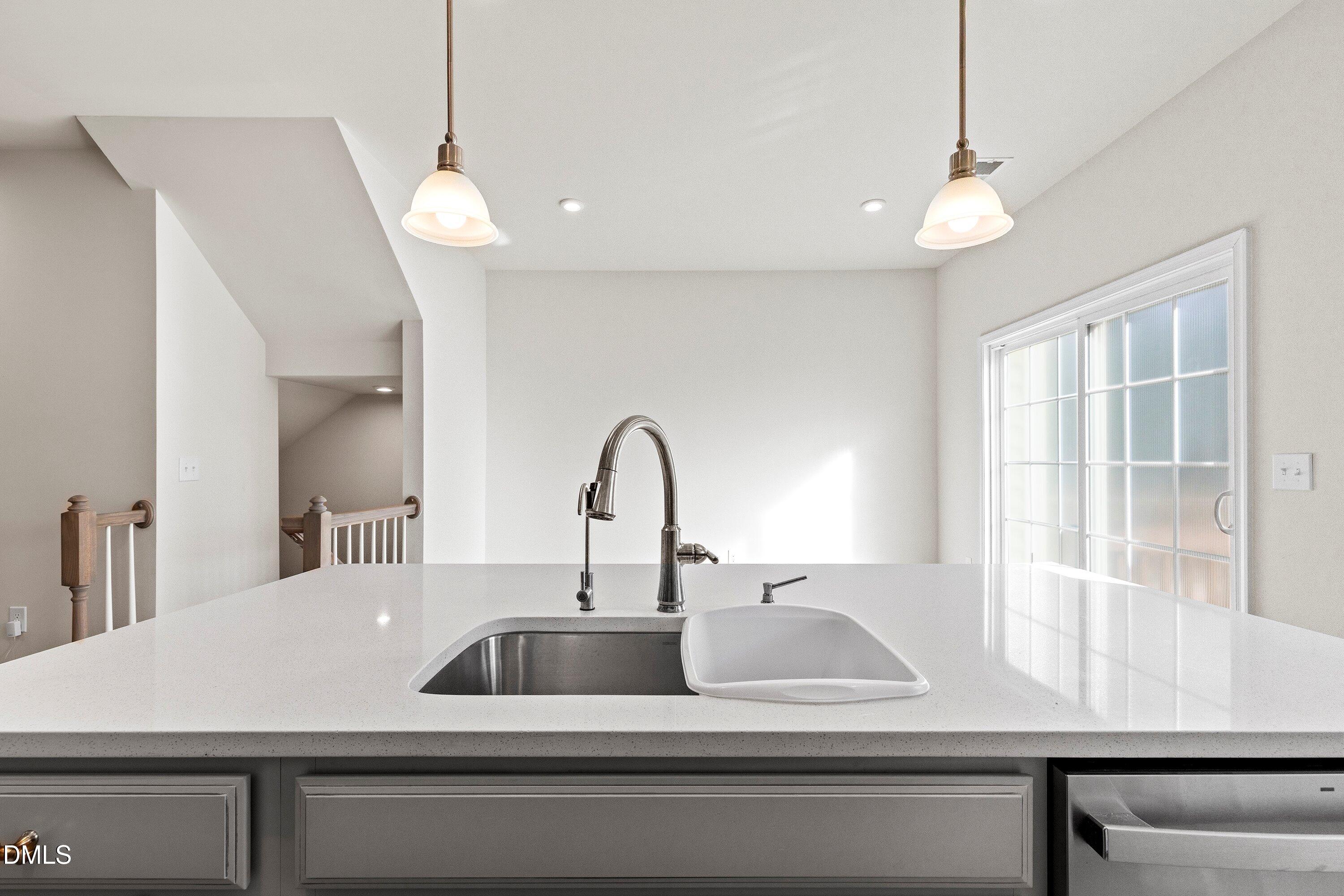 6430 Pathfinder Way Raleigh, NC 27616 - Photo 12 of 39 a kitchen with a sink and a large window with wooden floor