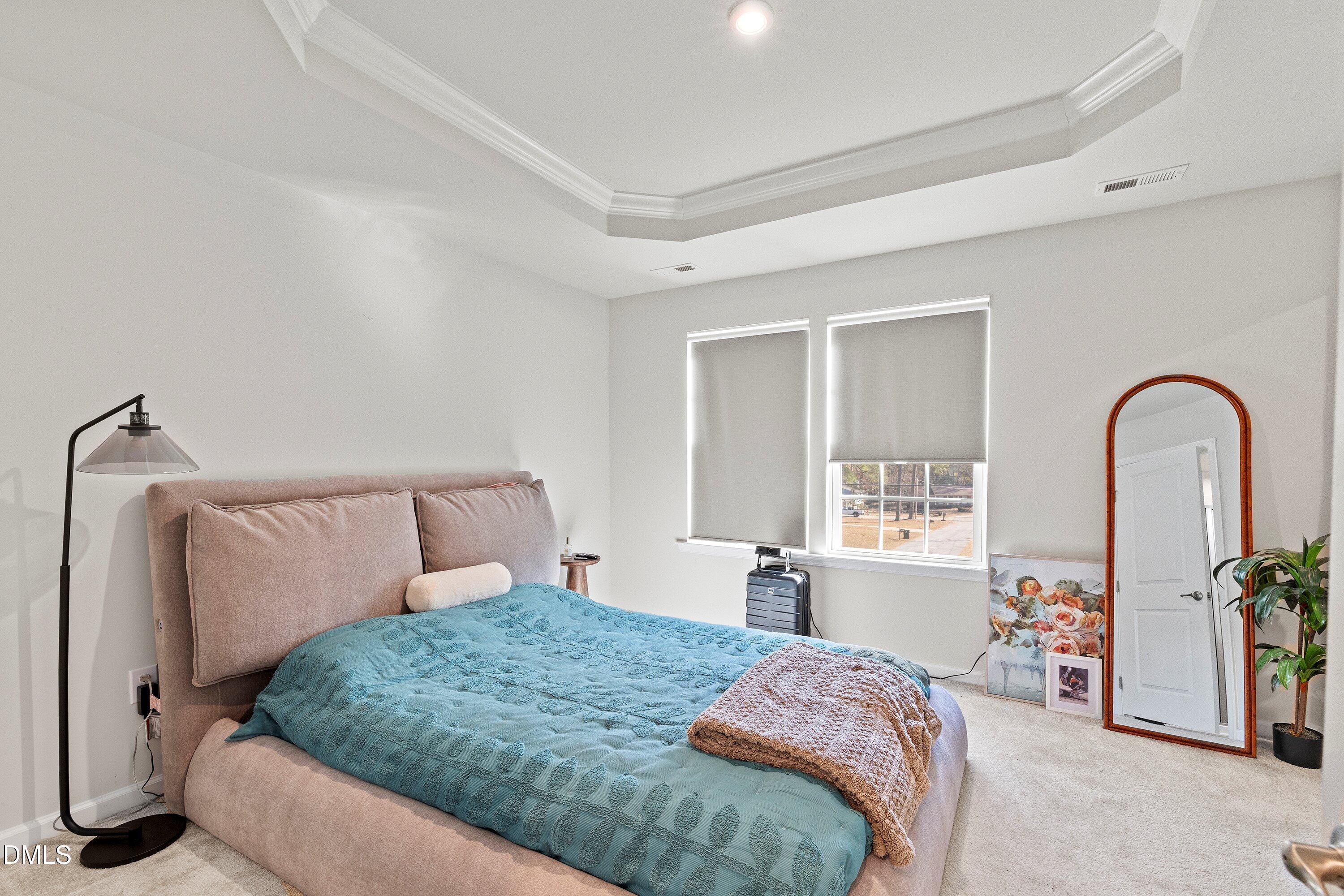 6430 Pathfinder Way Raleigh, NC 27616 - Photo 22 of 39 a bedroom with a bed and a dresser with mirror