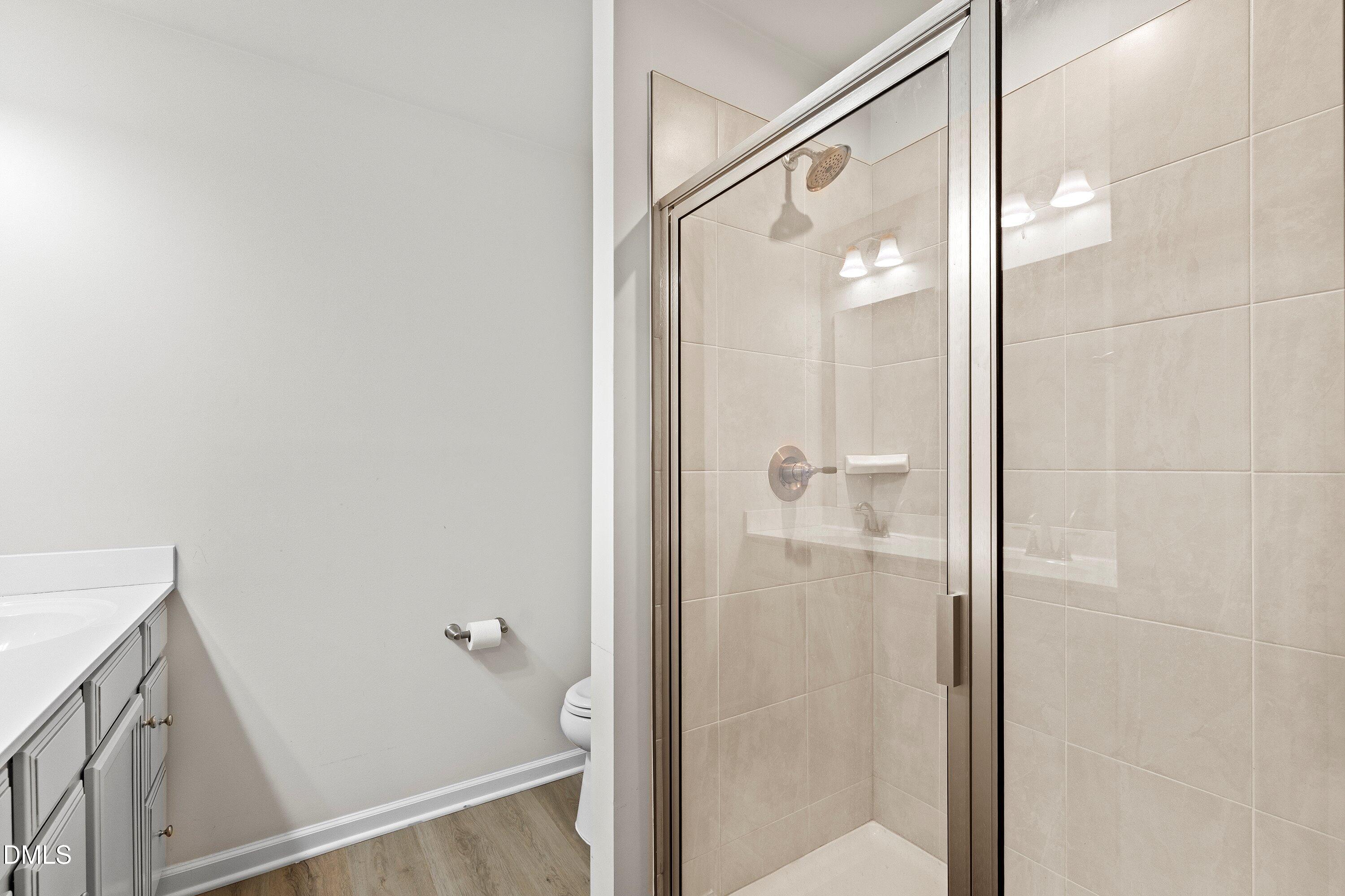 6430 Pathfinder Way Raleigh, NC 27616 - Photo 26 of 39 a bathroom with a glass shower door and a mirror