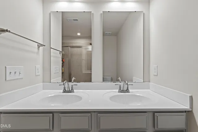 a bathroom with a glass shower door and a mirror