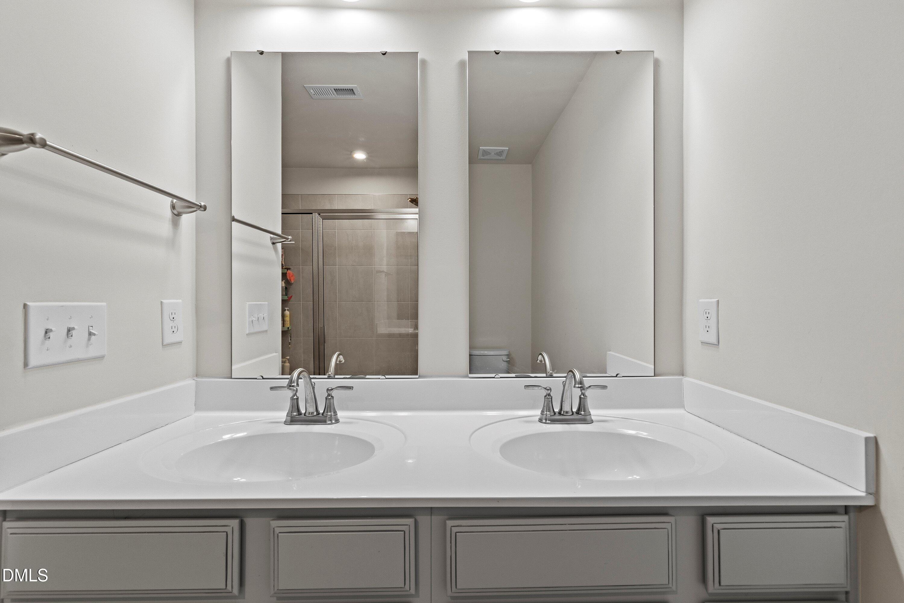 6430 Pathfinder Way Raleigh, NC 27616 - Photo 27 of 39 a bathroom with double sink and a mirror