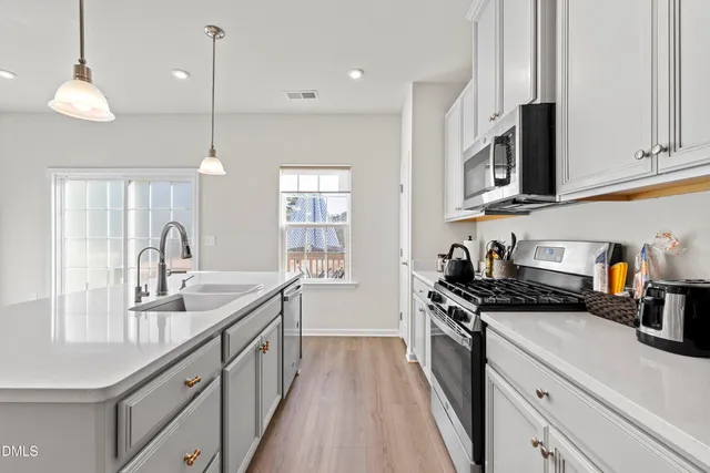 a view of kitchen with stainless steel appliances granite countertop refrigerator sink and microwave