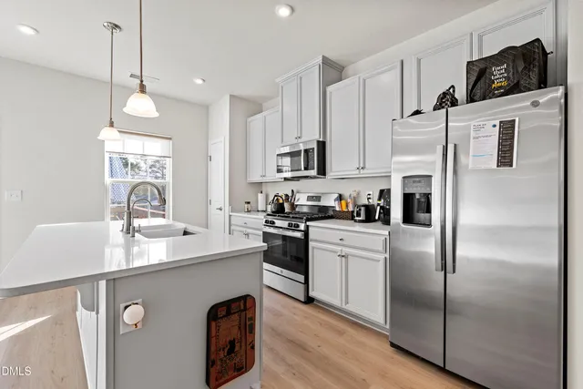 a kitchen with granite countertop a sink a stove and cabinets