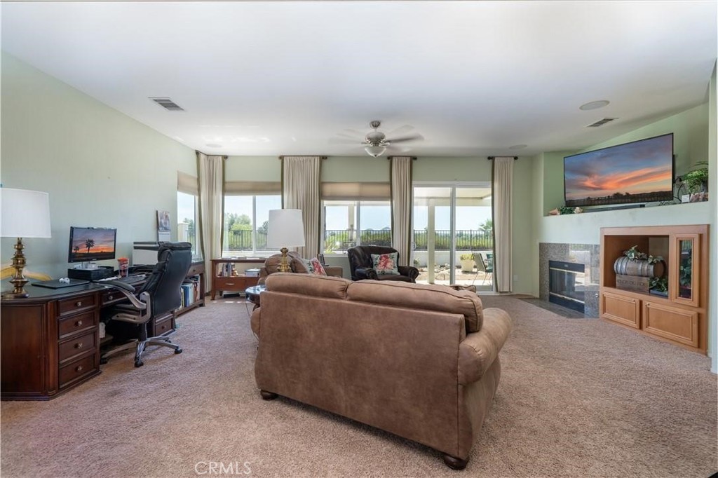 28433 Oasis View Circle Menifee, CA 92584 - Photo 10 of 26 a living room with furniture a flat screen tv and a fireplace