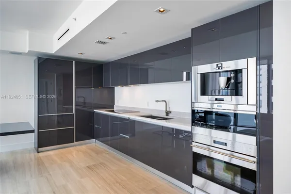a kitchen with stainless steel appliances a stove a microwave and a sink
