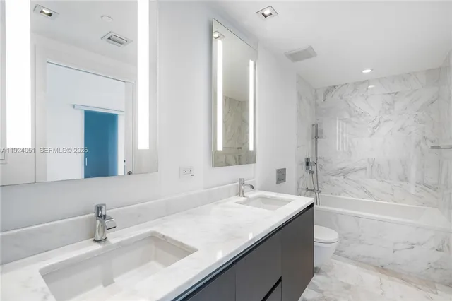 a bathroom with a granite countertop sink mirror and a bath tub
