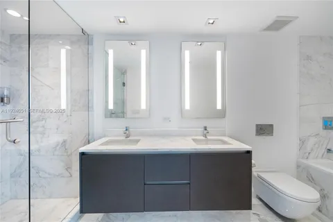 a bathroom with double sink and a mirror